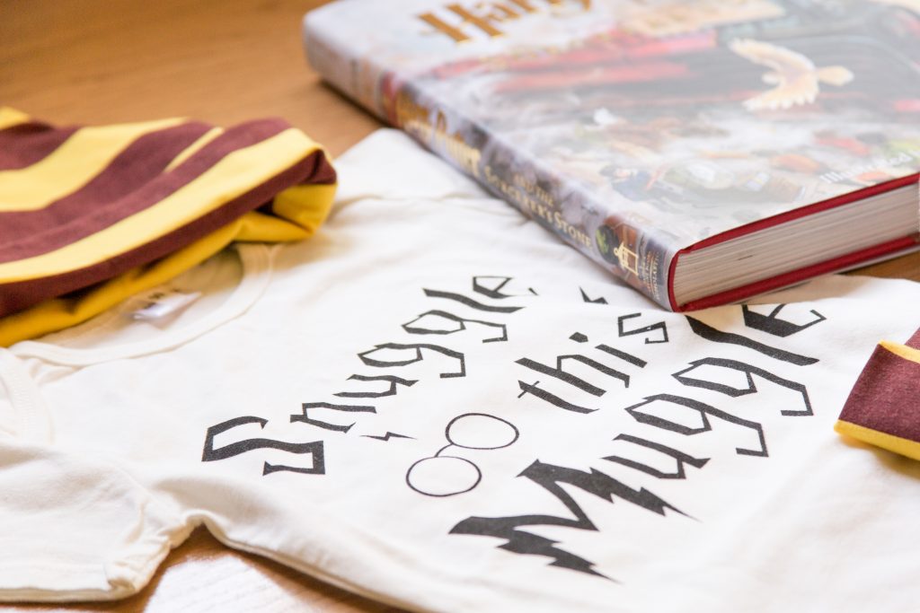 Close up of a white baby shirt with the words snuggle this muggle